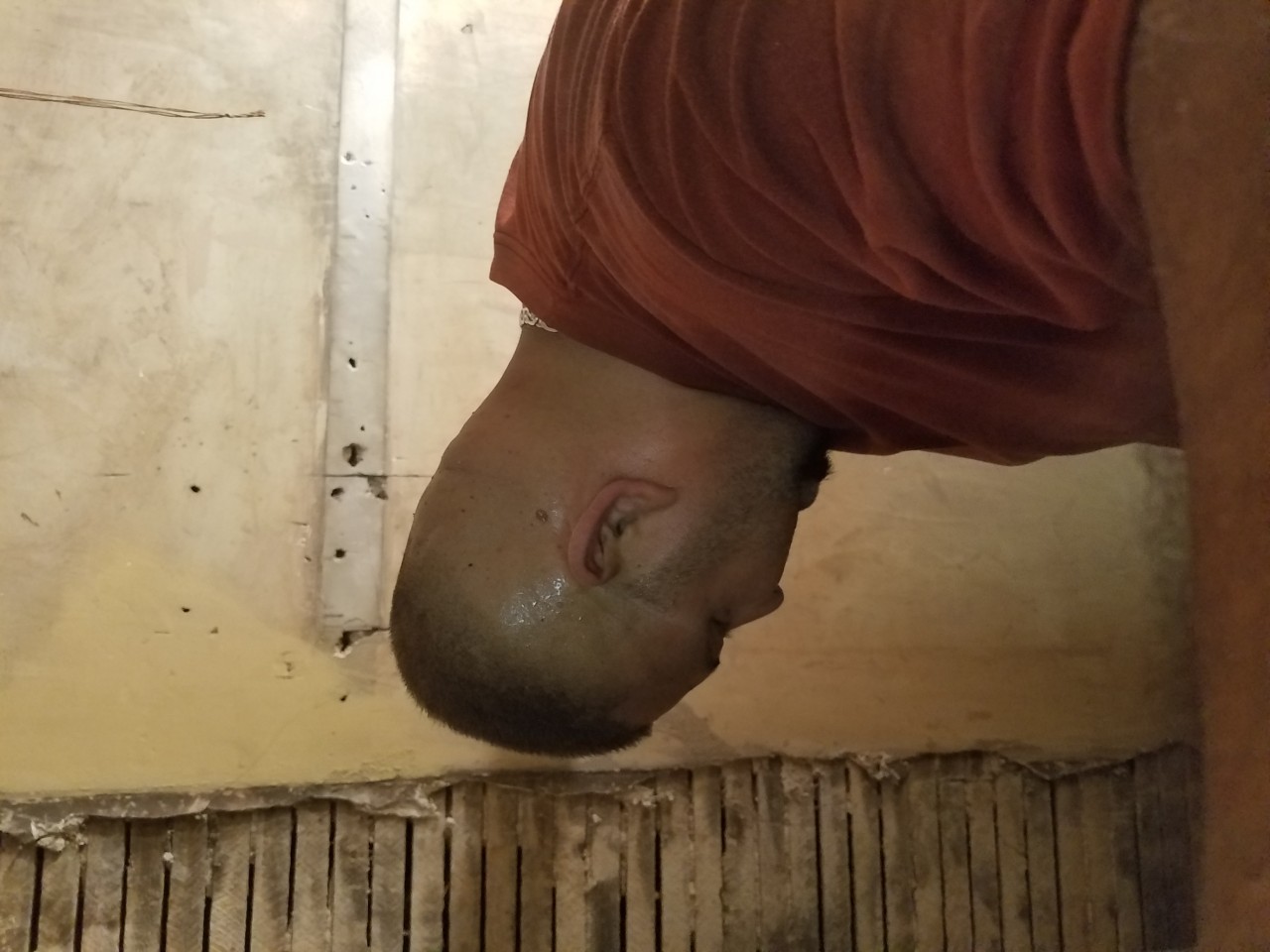 Gelacio upstairs in a closet taking the chimney down brick by brick